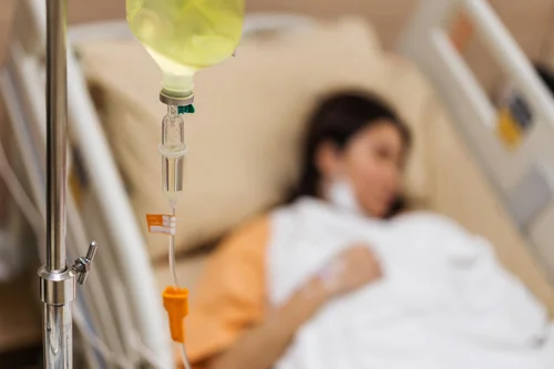 женщина лежит под капельницей трентала